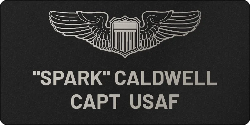 Custom 2x4 military flight suit name tag, black leatherette engraved silver with Air Force pilot wings, name and rank